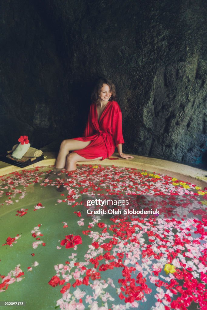 Mulher tomando jacuzzi com pétalas de flores