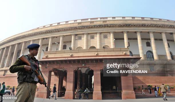An Indian Paramilitary Force soldier stands guard in front of Parliament House at the start of the winter session of Parliament in New Delhi on...
