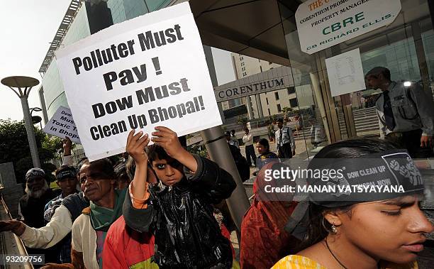 Survivors of the 1984 Bhopal gas leak tragedy and activists shout slogans and hold placards outside the Dow Chemicals office in Noida, around 40kms...