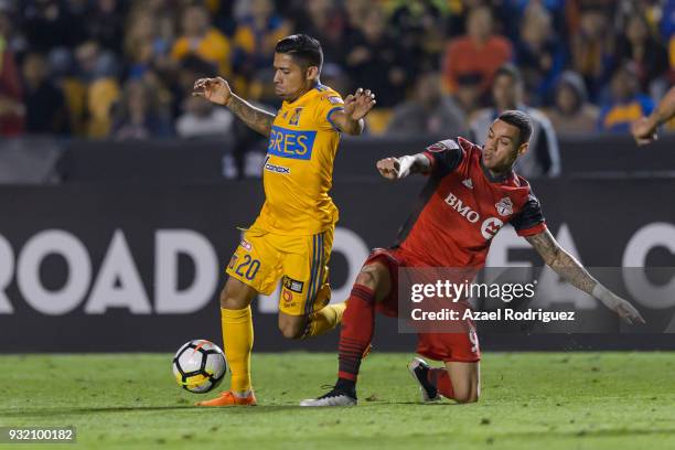 Javier Aquino of Tigres fights for the ball with Gregory Van Der Wiel of Toronto during the quarterfinals second leg match between Tigres UANL and...