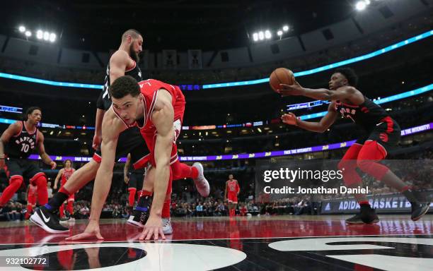 Zach LaVine of the Chicago Bulls hits the floor after having his shot blocked by Jonas Valanciunas of the Toronto Raptors at the United Center on...