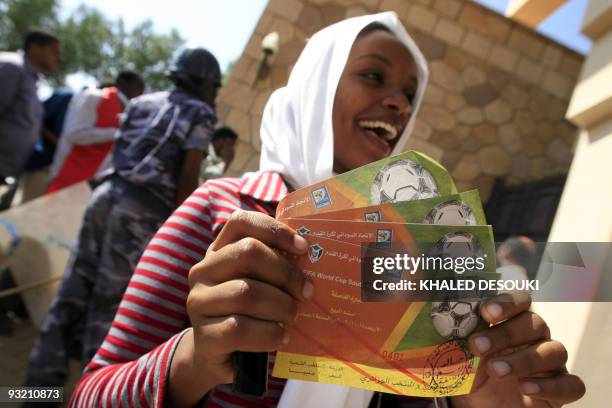 Sudanese woman smiles after getting tickets for the World Cup qualifier football match between Egypt and Algeria from the Egyptian embassy in...