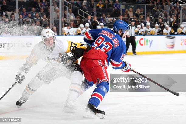 Mika Zibanejad of the New York Rangers skates with the puck against Sidney Crosby of the Pittsburgh Penguins at Madison Square Garden on March 14,...