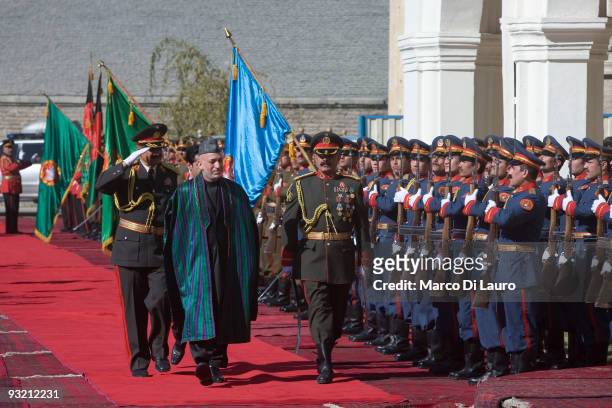President Hamid Karzai walks in front of a guard of honour as he arrives for the Inauguration ceremony at the presidential palace on November 19,...