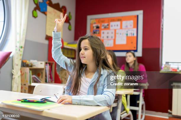 studentessa che alza la mano a lezione - retrieving foto e immagini stock
