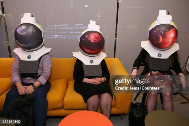 Guests try out rear-projection space helmets at National Geographics world premiere screening of One Strange Rock on Wednesday, March 14, 2018 in...