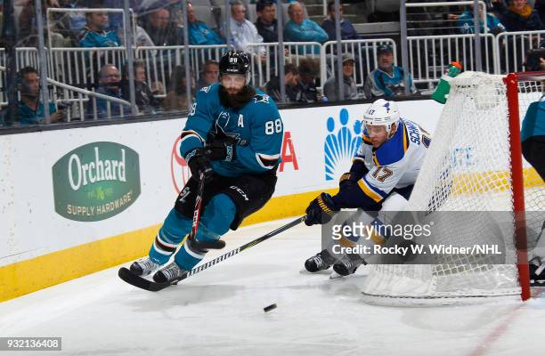 Brent Burns of the San Jose Sharks skates after the puck against Jaden Schwartz of the St. Louis Blues at SAP Center on March 8, 2018 in San Jose,...