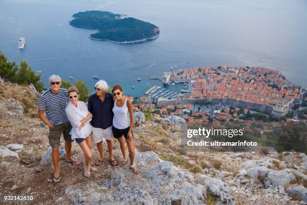 friends  two couple enjoying holidays senior man and young woman. tourists. mediterranean sea viewpoint above dubrovnik. - croatia tourist stock pictures, royalty-free photos & images