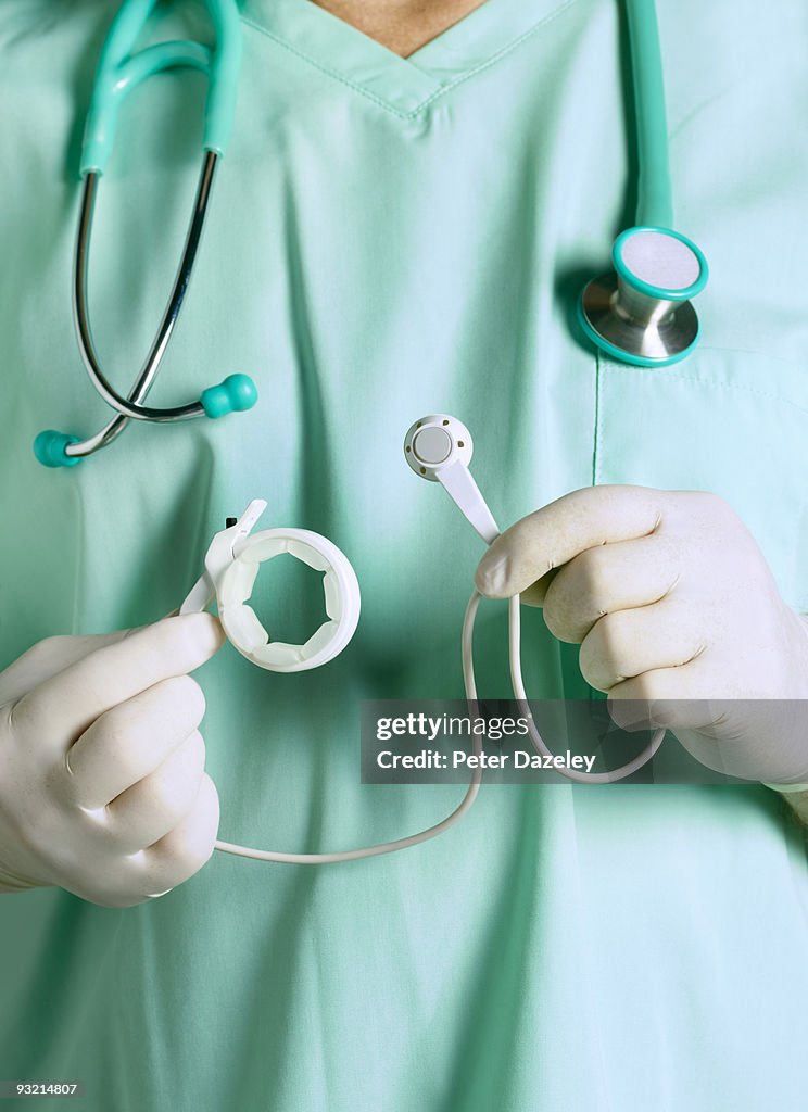 Surgeon in scrubs with gastric band.
