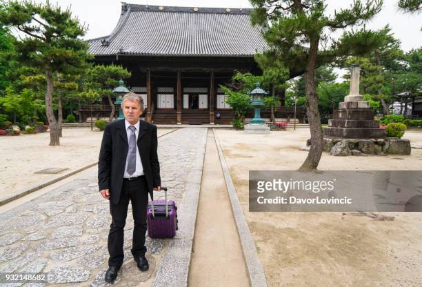 zakenman in japanse tuin bij ingang naar de chion-ji-tempel in kyoto, japan - lypsekyo16 stockfoto's en -beelden