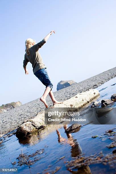 eight year old girl walking on a piece o driftwood - mendocino stock pictures, royalty-free photos & images