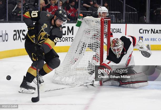 Keith Kinkaid of the New Jersey Devils knocks the puck away from Tomas Tatar of the Vegas Golden Knights in the second period of their game at...