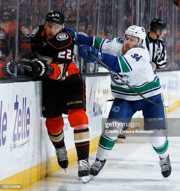 Tyler Motte of the Vancouver Canucks checks Chris Kelly of the Anaheim Ducks during the game on March 14, 2018 at Honda Center in Anaheim, California.