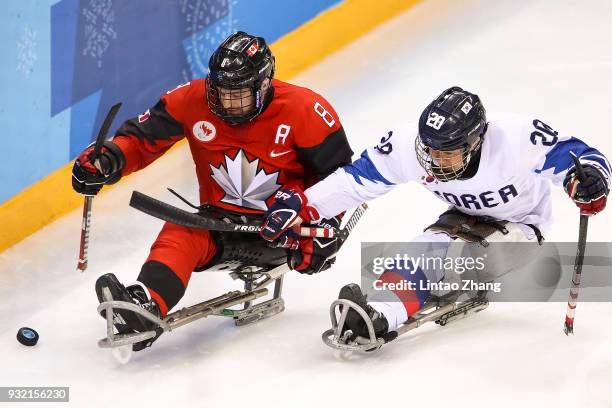 Tyler McGregor of Canada battles for the puck with Jang Dong Shin of Korea in the Ice Hockey semi final game during day six of the PyeongChang 2018...