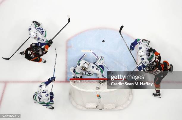 Darren Archibald, Henrik Sedin Jacob Markstrom and Alex Biega of the Vancouver Canucks defend against Adam Henrique and Ondrej Kase of the Anaheim...