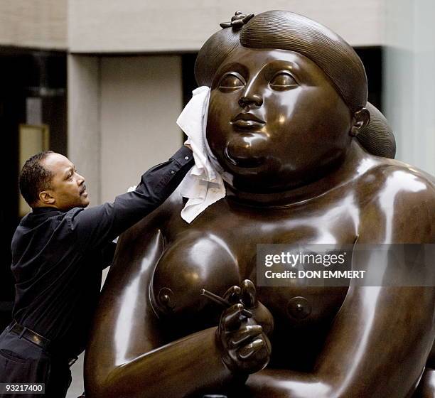 Christie's employee buffs the Mujer Fumando by Fernando Botero during Christie's press preview for Latin American Arts sale November 13, 2009 in New...