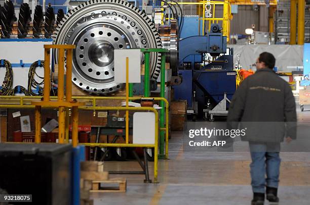 An employee of General Electric passes by a gas turbine at GE Energy Belfort's plant on November 19, 2009. GE Energy in Belfort produces medium- and...