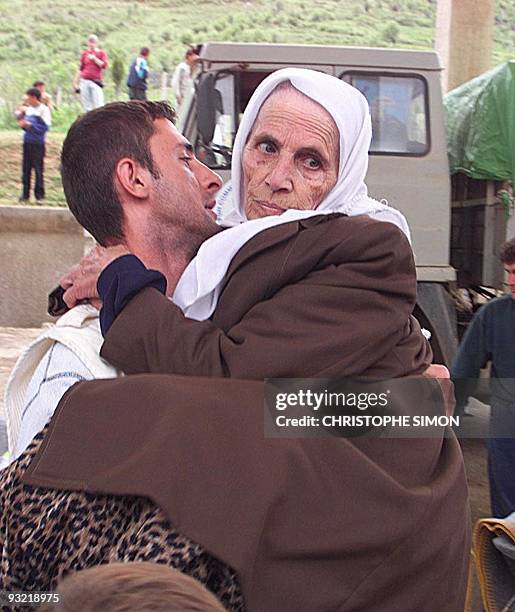 Medecins du Monde worker helps an elderly ethnic Albanian woman from the Kosovo town of Orahovac, who collapsed after arriving at the border-post in...