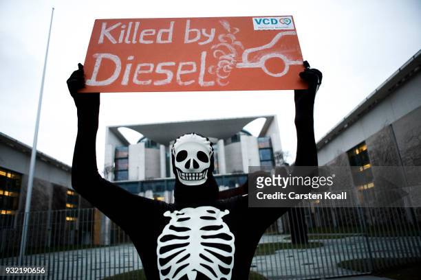 Protester holds a banner during a protest by cyclists against the ongoing diesel affair in front of the Chancellory as the new German Cabinet held...