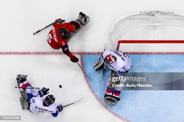 Rob Armstrong of Canada battles for the puck with a goalkeeper Jae Woong Lee of Korea in the Ice Hockey semifinals game between Canada and Korea...