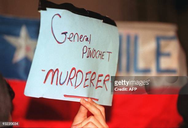 Demonstrator holds up a sign at the prestigious London Clinic 19 October where former Chilean dictator Augusto Pinochet is believed to be recovering...