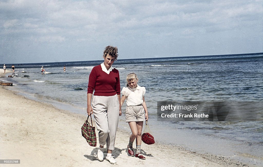 Mother and daughter at the beach walking