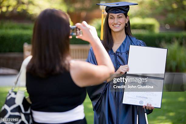 mom taking a picture of her daughter with diploma. - degree stock pictures, royalty-free photos & images