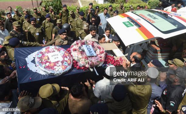 Pakistani policemen carry the coffin of a colleague during their funeral ceremony in Lahore on March 15 following an overnight suicide attack. At...