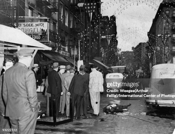 Outside the 'O Sole Mio Scungilli Bar and Seafood Restaurant' on Mulberry Street, detectives and police officers gather at the site of a murder where...