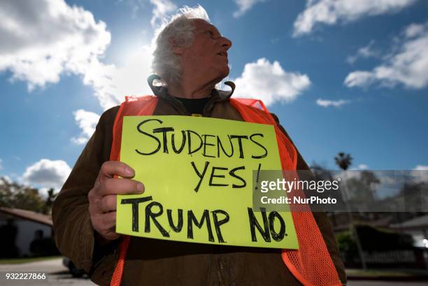 Chuck Levin holds a sign in font of John Marshall High School during a protest against gun violence in Los Angeles, California on March 14, 2018....