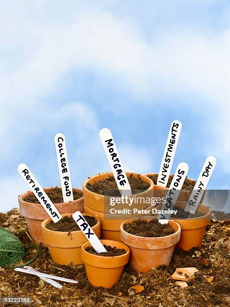 family expense flower pots. - saving for a rainy day englische redewendung stock-fotos und bilder