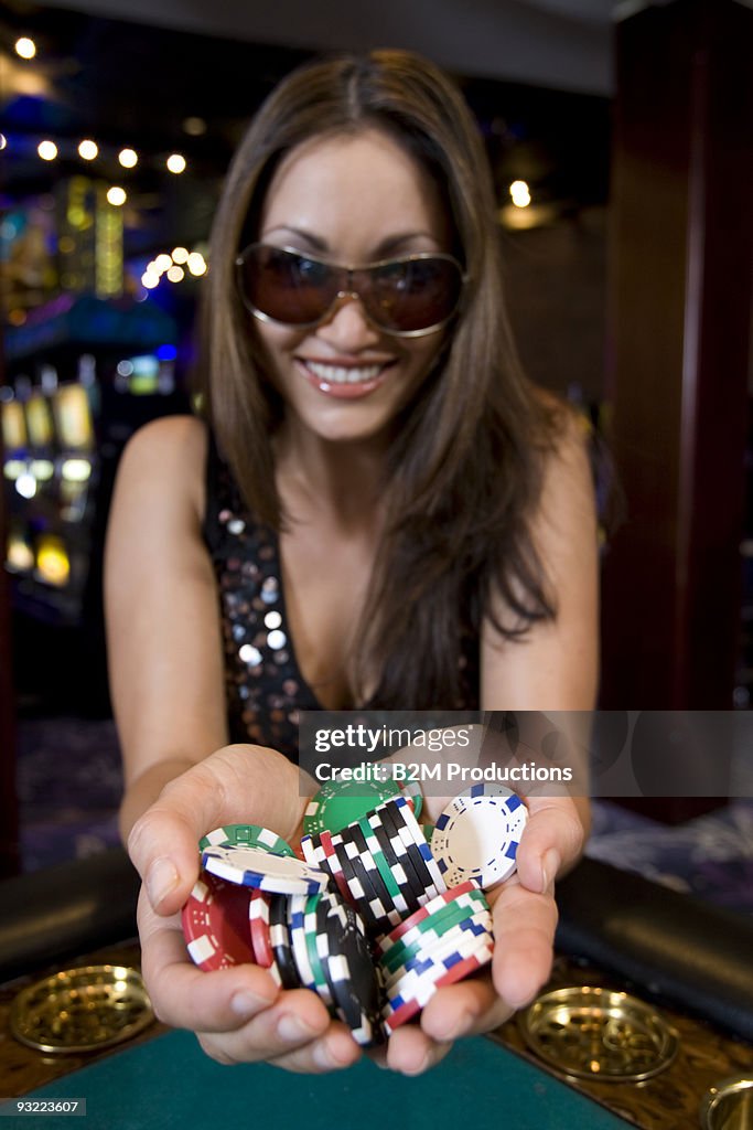 Woman holding gambling chips in casino