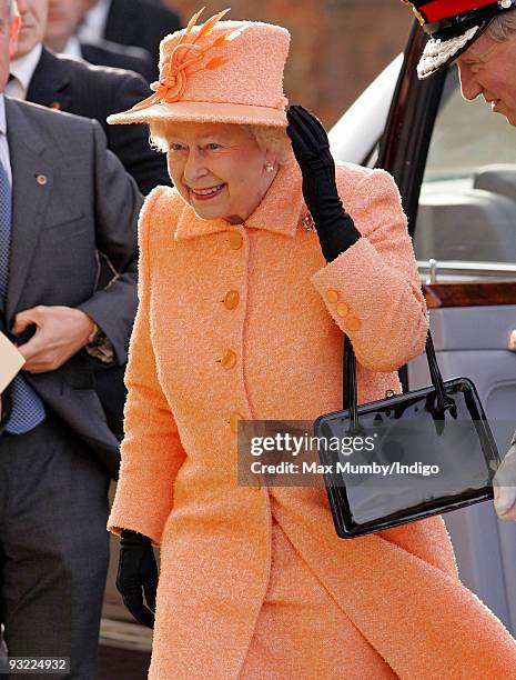 Queen Elizabeth II holds onto her hat in the high wind as she attends the 900th anniversary celebrations of the Diocese of Ely at Ely Cathedral on...