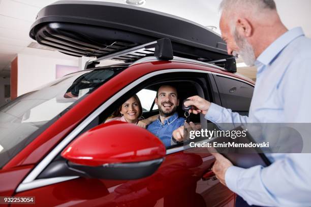 夫婦收到汽車銷售人員的新車鑰匙 - buying a car 個照片及圖片檔