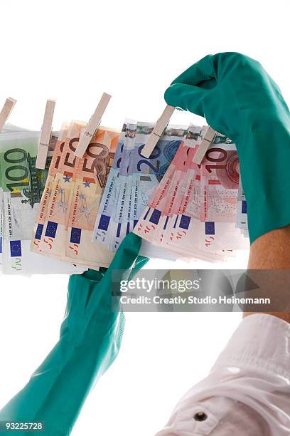 person hanging different euro notes on clothesline, close-up - washing up glove - fotografias e filmes do acervo