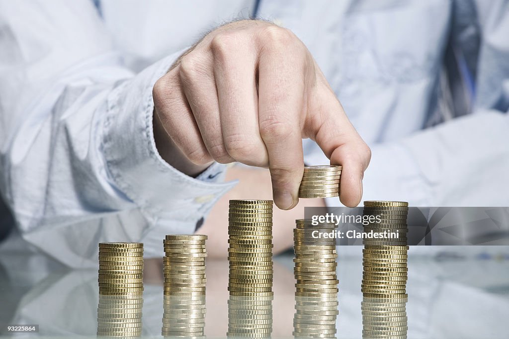Person stacking Euro coins, close up