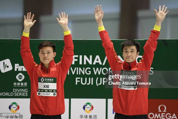 Yuan Cao and Siyi Xie of China celebrate on the podium after winning in the Men's 3m Synchro Platform final during day one of the FINA Diving World...
