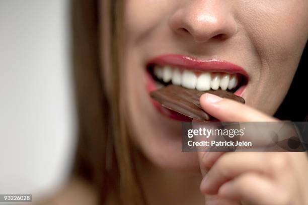 young woman eating chocolate candy, portrait - chocolate happy stock pictures, royalty-free photos & images