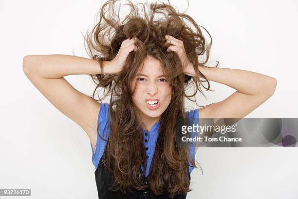 young woman (16-17) tearing her hair - tearing your hair out photos et images de collection