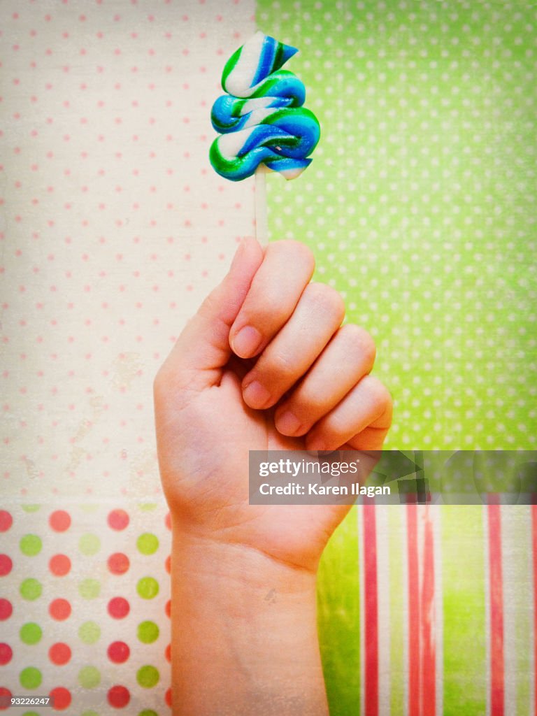 Closeup of hand holding a lollipop