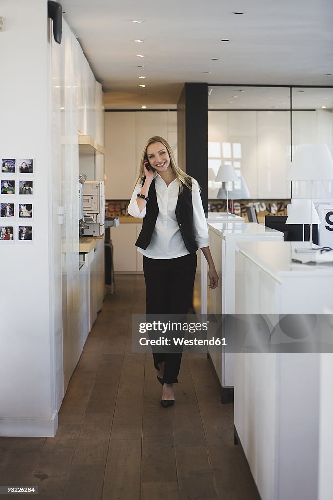 Business woman in office using mobile phone