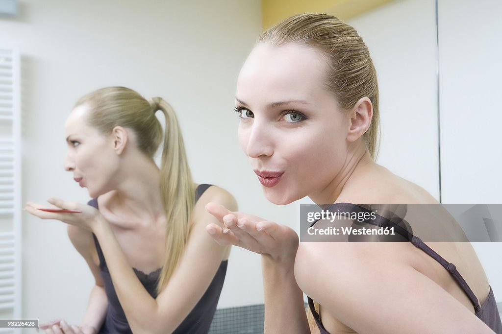 Young woman blowing kiss, portrait