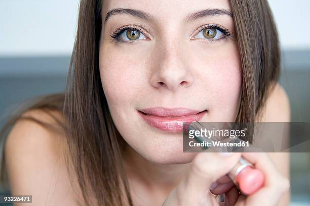 young woman applying lipstick, portrait, close-up - apply lipstick stock pictures, royalty-free photos & images