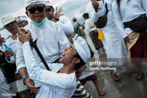 Balinese ritual trance in melasti in Petitenget beach on March 14, 2018 in Bali, Indonesia. The melasti ritual is aimed at self-purification which is...