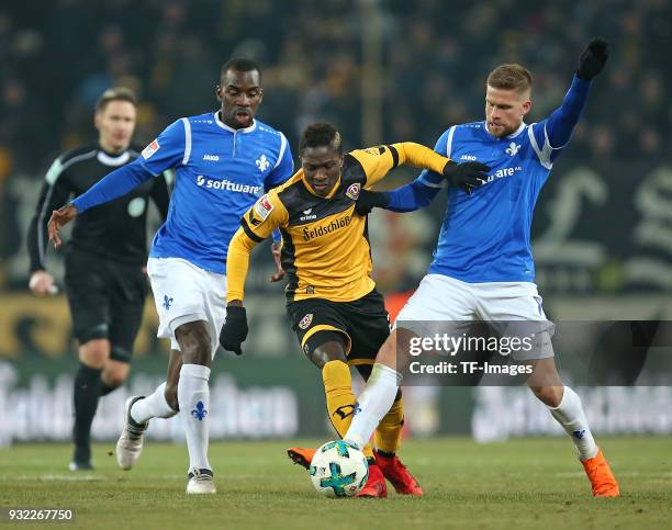 Wilson Kamavuaka of Darmstadt, Moussa Kone of Dresden and Tobias Kempe of Darmstadt battle for the ball during the Second Bundesliga match between SG...