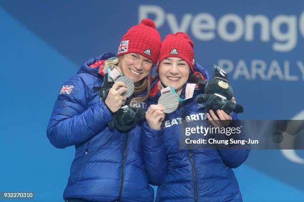 Silver medallist Menna Fitzpatrick of Great Britain and her guide Jennifer Kehoe celebrate on the podium during the medal ceremony for the Alpien...