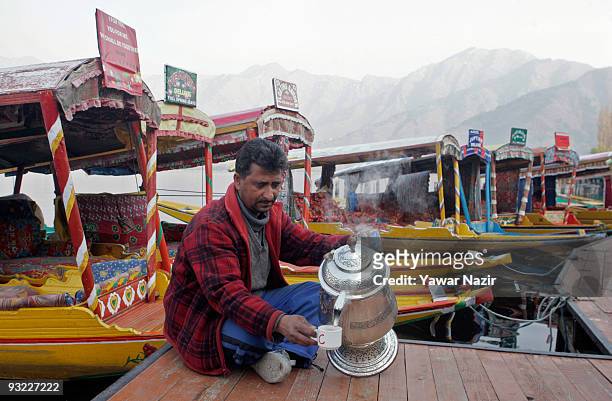 Kashmiri pours tea from a samovar next to shikaras in Dal Lake on November 19, 2009 in Srinagar, the summer capital of Indian held Jammu and Kashmir...