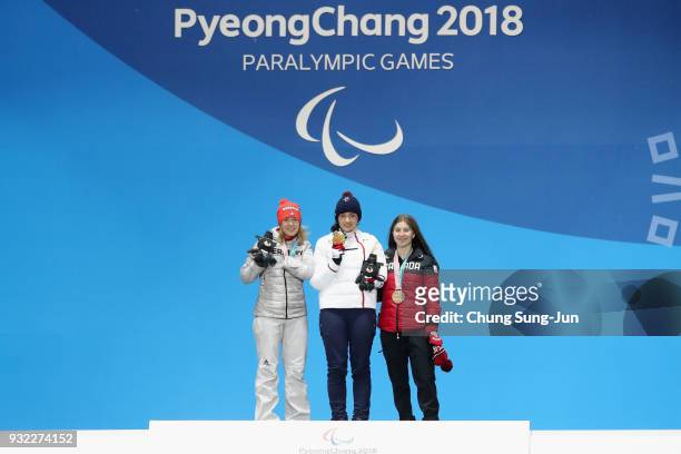 Silver medallist Andrea Rothfuss of Germany, Gold medallist Marie Bochet of France and Bronze medallist Mollie Jepsen of Canada celebrate on the...
