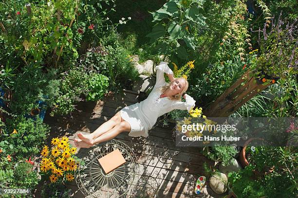 austria, salzburger land, young woman in garden, relaxing, elevated view - domestic garden photos et images de collection