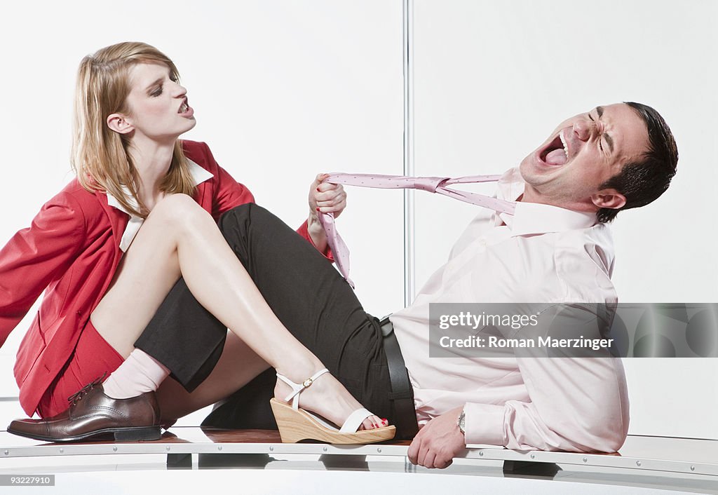 Germany, Business woman pulling Businessman's Tie